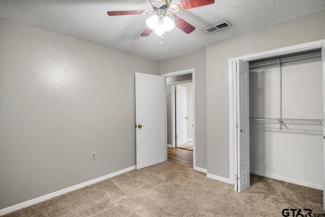 303 Westwood Dr, Troup, TX 75789 - unfurnished bedroom with carpet, a textured ceiling, a closet, baseboards, and ceiling fan