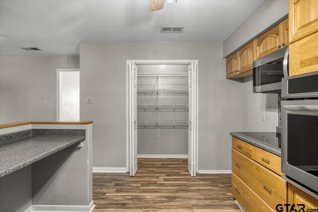 303 Westwood Dr, Troup, TX 75789 - kitchen featuring appliances with stainless steel finishes, dark wood-style floors, dark countertops, and baseboards