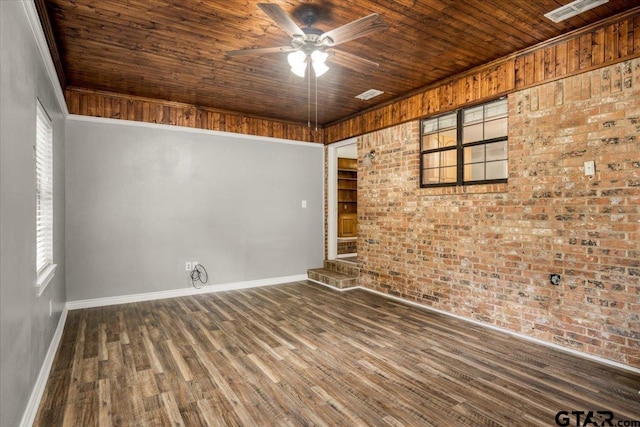 303 Westwood Dr, Troup, TX 75789 - empty room featuring brick wall, wooden ceiling, ceiling fan, baseboards, and wood finished floors