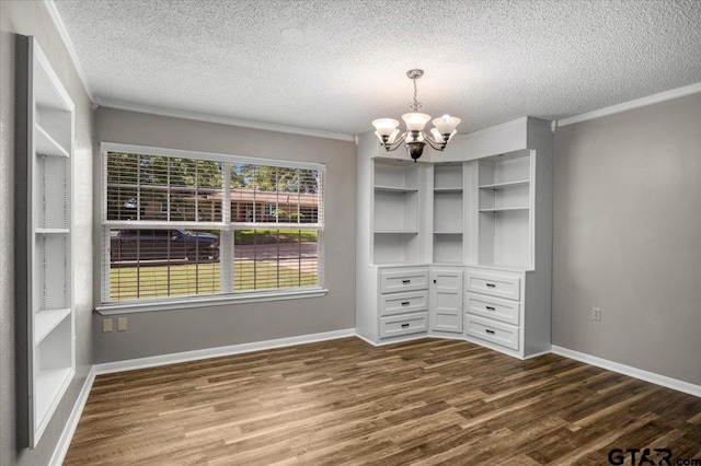 303 Westwood Dr, Troup, TX 75789 - unfurnished dining area with a chandelier, dark wood-type flooring, a textured ceiling, crown molding, and baseboards