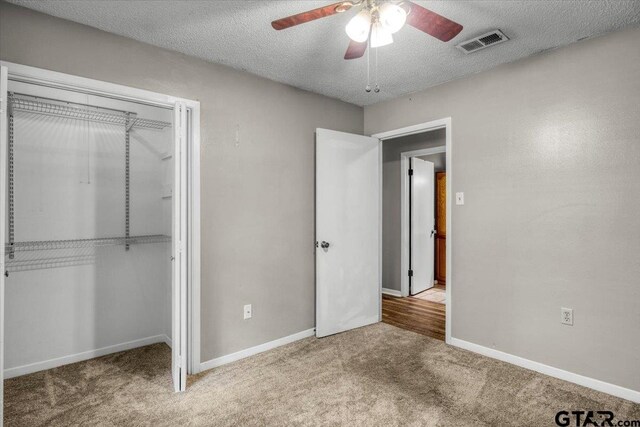 303 Westwood Dr, Troup, TX 75789 - unfurnished bedroom featuring carpet, a textured ceiling, a closet, baseboards, and ceiling fan