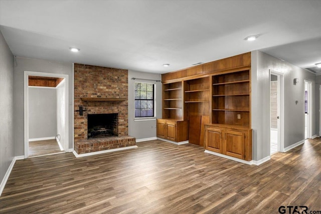 303 Westwood Dr, Troup, TX 75789 - unfurnished living room featuring baseboards, a fireplace, dark wood-type flooring, recessed lighting, and built in features