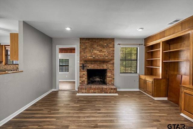 303 Westwood Dr, Troup, TX 75789 - unfurnished living room with dark wood-style flooring, a fireplace, and baseboards