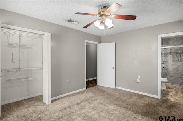 303 Westwood Dr, Troup, TX 75789 - unfurnished bedroom with carpet, ensuite bath, a closet, a ceiling fan, and baseboards