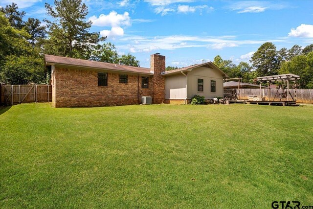 303 Westwood Dr, Troup, TX 75789 - rear view of property with a chimney, a wooden deck, brick siding, and cooling unit
