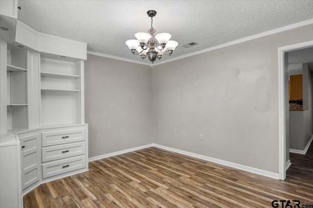 303 Westwood Dr, Troup, TX 75789 - unfurnished dining area with a chandelier, dark wood finished floors, a textured ceiling, baseboards, and crown molding