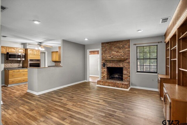 303 Westwood Dr, Troup, TX 75789 - unfurnished living room featuring a fireplace, a ceiling fan, dark wood-style flooring, baseboards, and recessed lighting