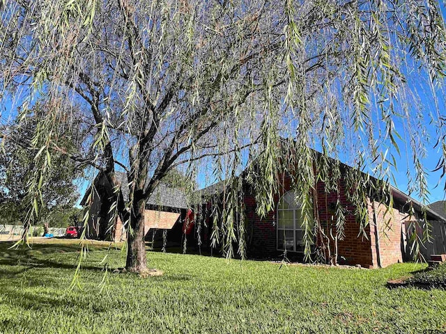 view of side of home with a yard