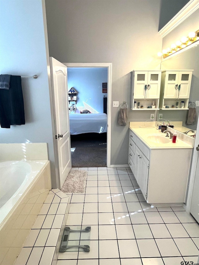 bathroom with tiled bath, tile patterned flooring, and vanity