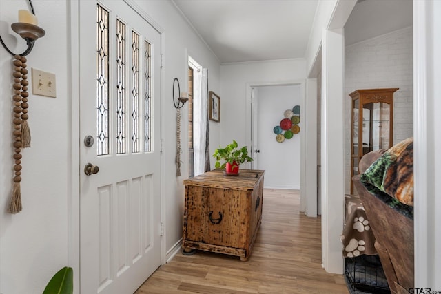 entrance foyer featuring crown molding and light wood-type flooring