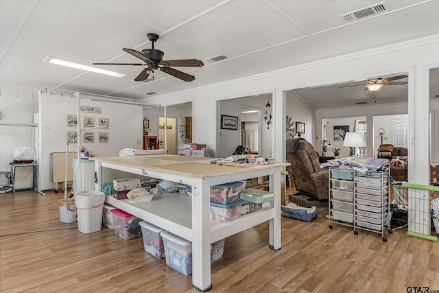 bedroom featuring ceiling fan, crown molding, and light wood-type flooring