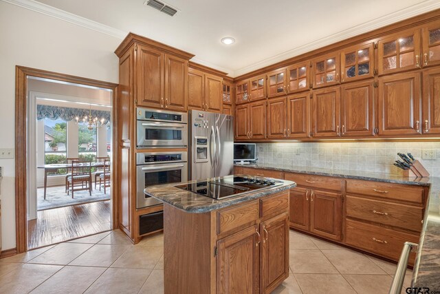 215 S Bay Dr, Bullard, TX 75757 - kitchen featuring stainless steel fridge, brown cabinetry, black electric cooktop, light tile patterned floors, and a kitchen island