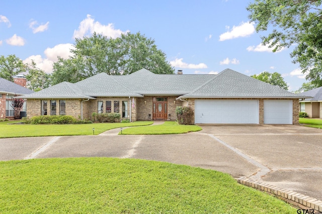 215 S Bay Dr, Bullard, TX 75757 - view of front of home featuring an attached garage, driveway, a front yard, a chimney, and brick siding