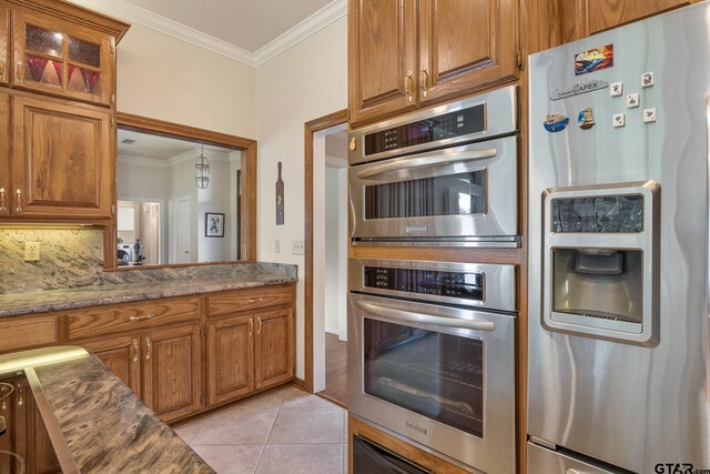 215 S Bay Dr, Bullard, TX 75757 - kitchen featuring stainless steel appliances, ornamental molding, brown cabinetry, and light tile patterned flooring