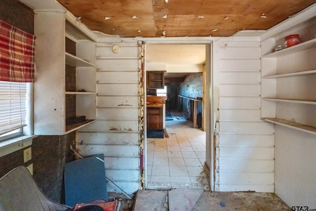 interior space featuring wooden ceiling and concrete flooring