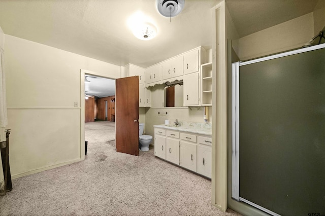 kitchen with light carpet, white cabinetry, and sink