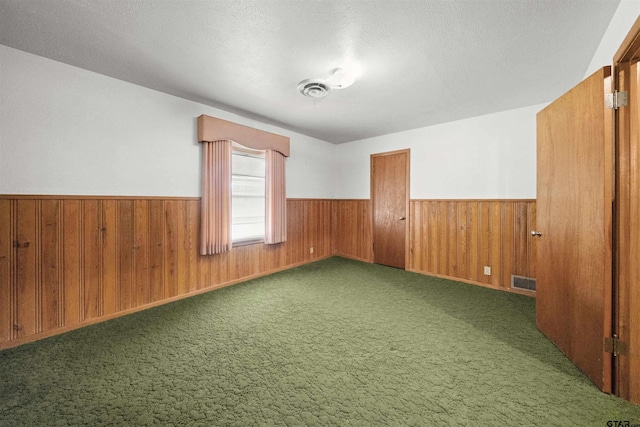 empty room with dark colored carpet and a textured ceiling