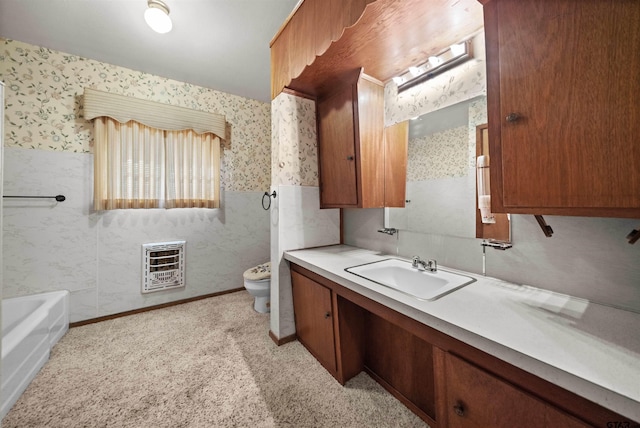 bathroom with vanity, heating unit, toilet, and a bathtub