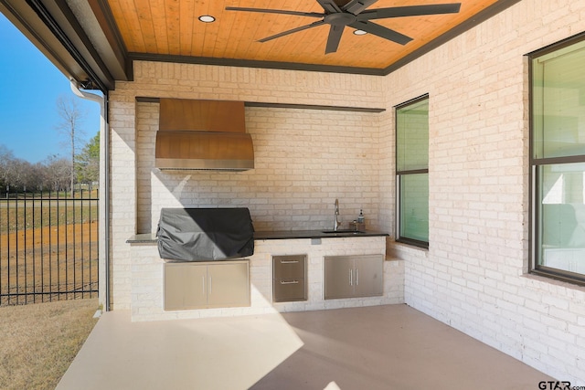 view of patio with area for grilling, a ceiling fan, a sink, a grill, and fence