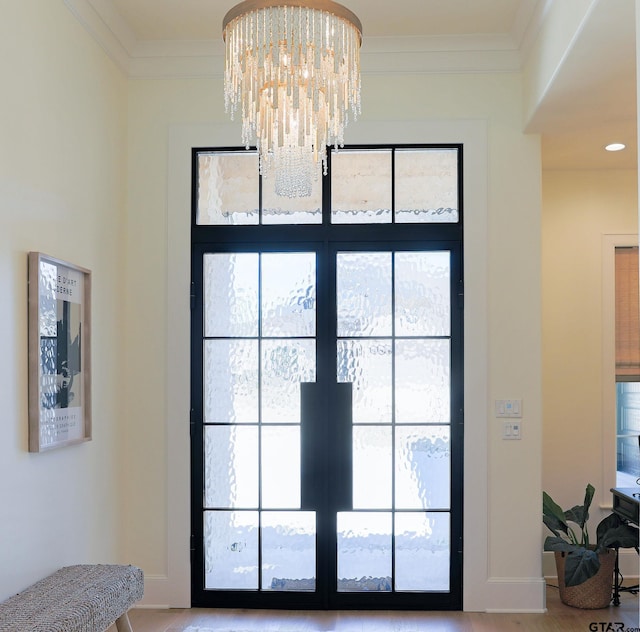 interior details with a chandelier, french doors, ornamental molding, and baseboards