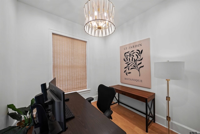 home office featuring a notable chandelier, baseboards, and wood finished floors