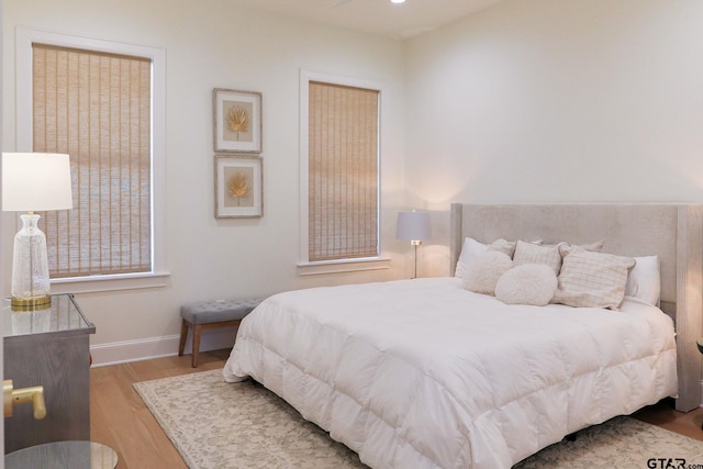 bedroom featuring light wood-style floors and baseboards