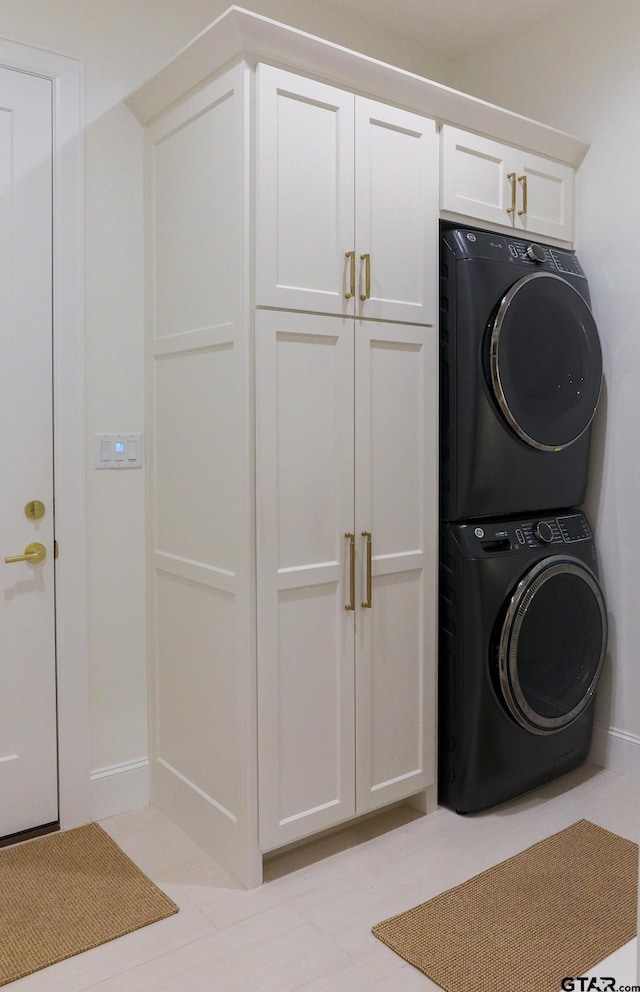 laundry room with stacked washer / dryer and cabinet space