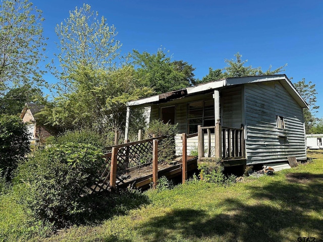 back of house with a lawn and a deck