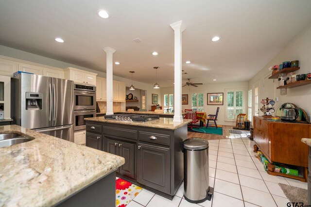 431 Gifford St, Rusk, TX 75785 - kitchen featuring appliances with stainless steel finishes, light stone counters, ornate columns, recessed lighting, and a center island