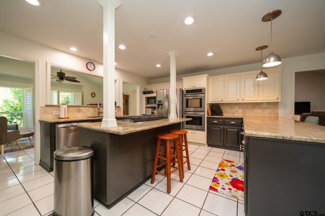 431 Gifford St, Rusk, TX 75785 - kitchen with appliances with stainless steel finishes, decorative columns, light tile patterned floors, tasteful backsplash, and a kitchen bar