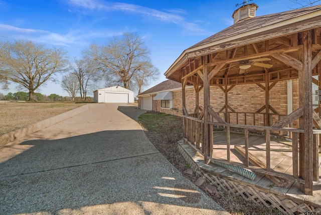 view of yard featuring a ceiling fan, an outbuilding, and a detached garage