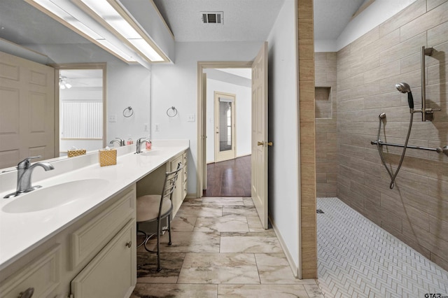 full bath with marble finish floor, visible vents, a walk in shower, and a sink