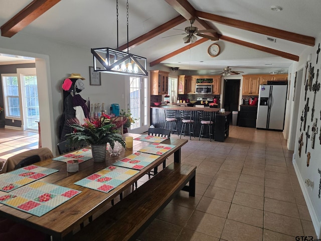 dining space featuring tile patterned floors, ceiling fan, and vaulted ceiling with beams