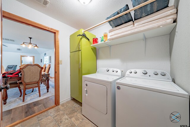 laundry room featuring a textured ceiling and washing machine and dryer