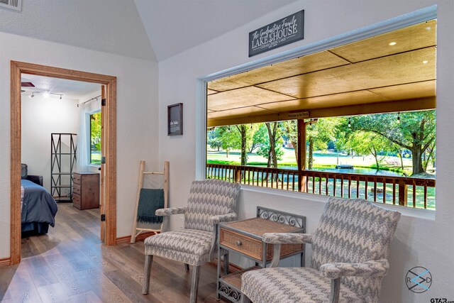 sitting room featuring hardwood / wood-style floors and vaulted ceiling