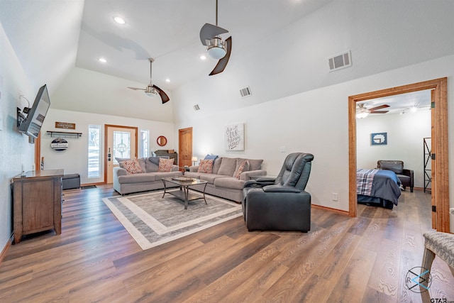 living room with high vaulted ceiling, ceiling fan, and dark wood-type flooring