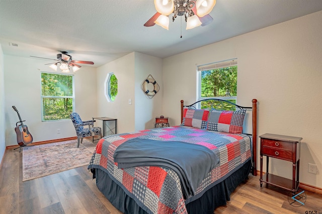 bedroom with ceiling fan and wood-type flooring