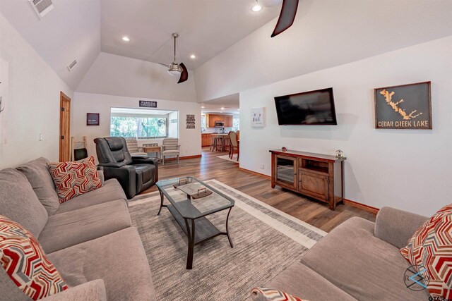 living room with hardwood / wood-style floors and high vaulted ceiling