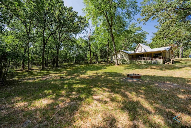 view of yard featuring an outdoor fire pit and a porch