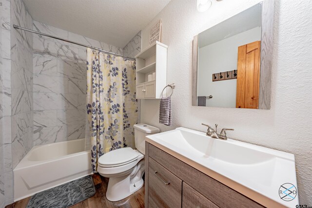 full bathroom featuring shower / tub combo, hardwood / wood-style floors, toilet, vanity, and a textured ceiling