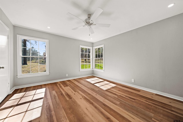 unfurnished room with baseboards, wood finished floors, and a healthy amount of sunlight