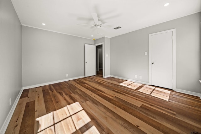 unfurnished bedroom with wood finished floors, visible vents, crown molding, and baseboards