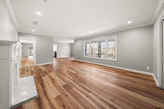 unfurnished living room with wood finished floors, recessed lighting, ornamental molding, and baseboards