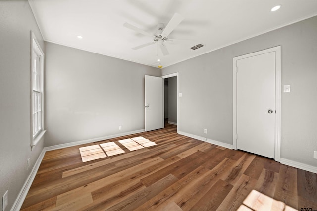 unfurnished bedroom featuring wood finished floors, visible vents, recessed lighting, and baseboards