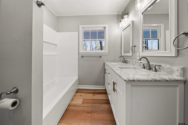 full bathroom featuring ornamental molding, wood finished floors, and a sink