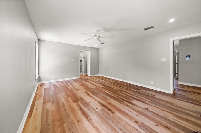 empty room with baseboards, visible vents, ceiling fan, and light wood-style floors