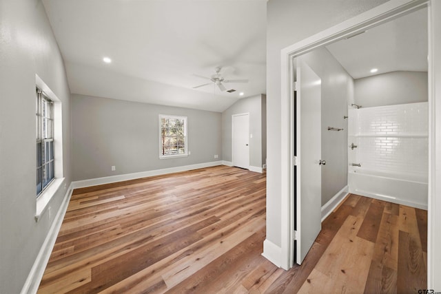 interior space with baseboards, recessed lighting, wood finished floors, and vaulted ceiling