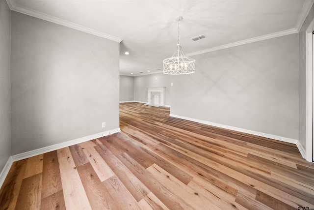 unfurnished dining area featuring baseboards, wood finished floors, a chandelier, and crown molding