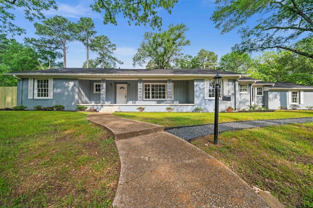 ranch-style house featuring fence, board and batten siding, a porch, and a front lawn