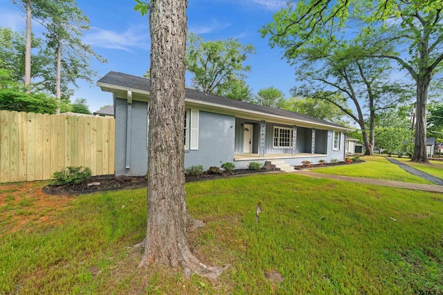 view of front of house with brick siding, fence, and a front yard